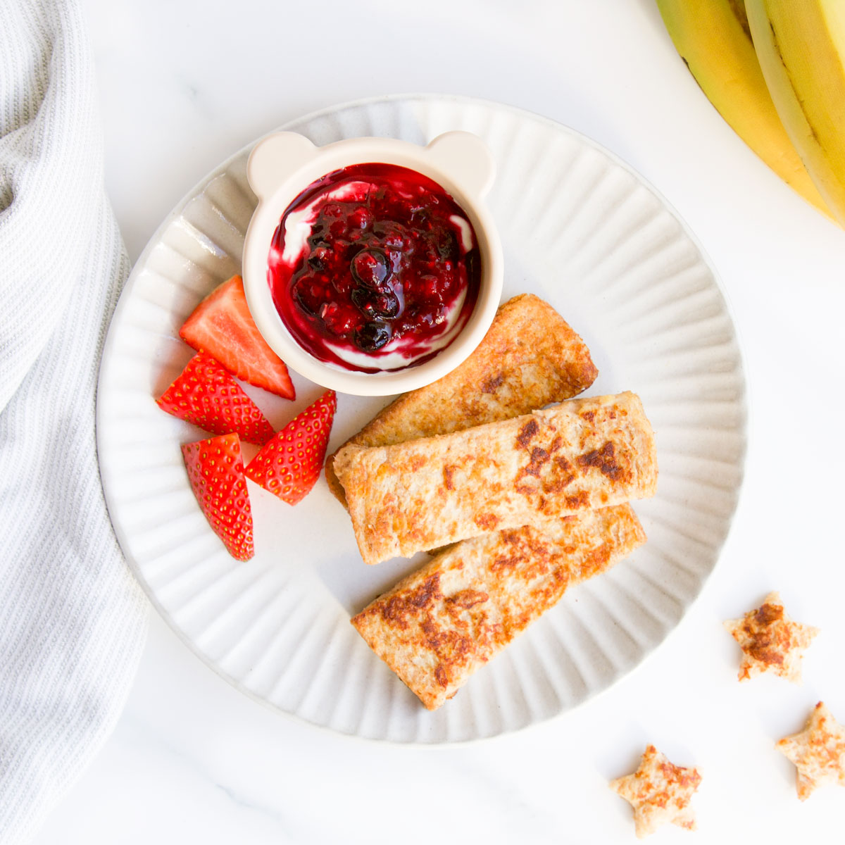 Banana French Toast Fingers on Plate Served with Strawberries and Berry Yogurt.