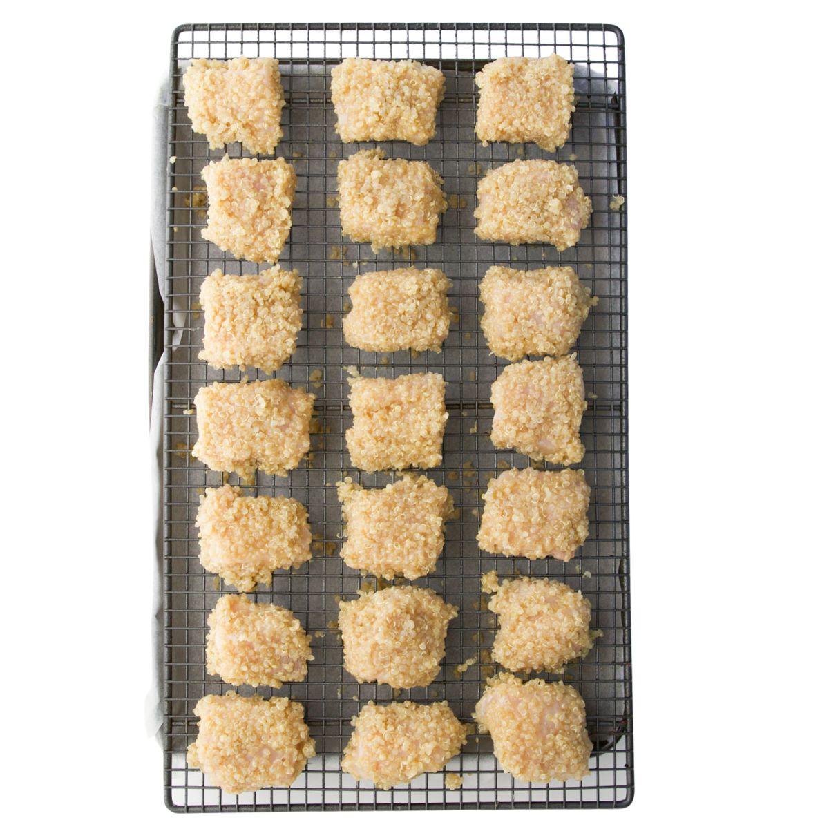 Quinoa Coated Chicken Nuggets on Tray Ready to Bake. 