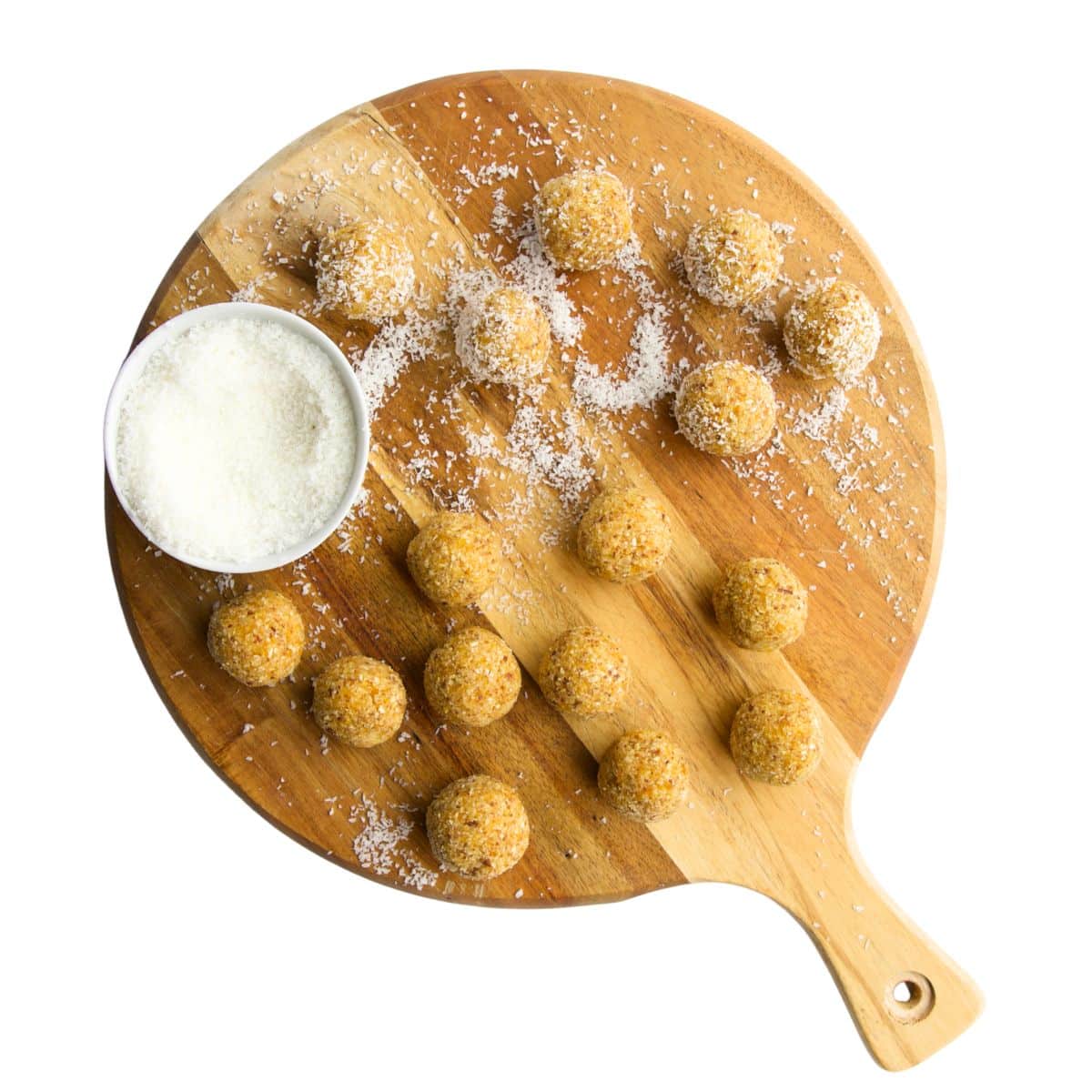 Tropical Balls on Round Wooden Board with Shredded Coconut on it for Rolling.