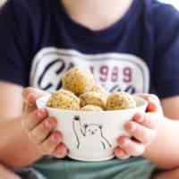 Child Holding Bowl of Apricot Balls