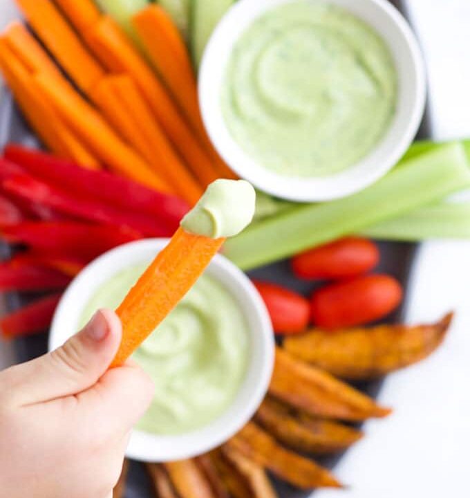 Child Dipping Carrot into Avocado Dip