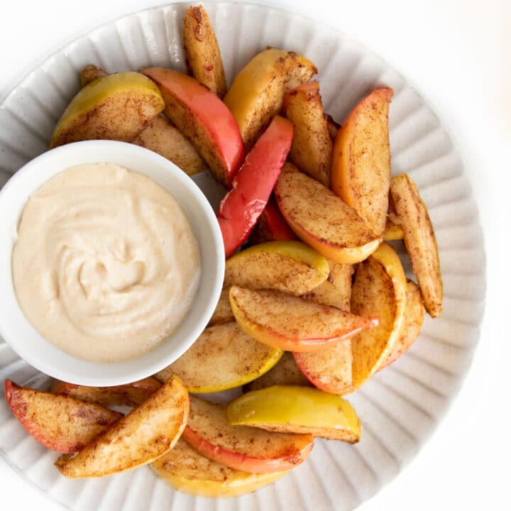 Baked Apple Slices Served on White Plate with Peanut Butter Dip.