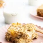 Baked Mango Oatmeal Pinterest Pin with Image Showing Tow Slices of Baked Oatmeal on Plate and Glass of Milk in Background.