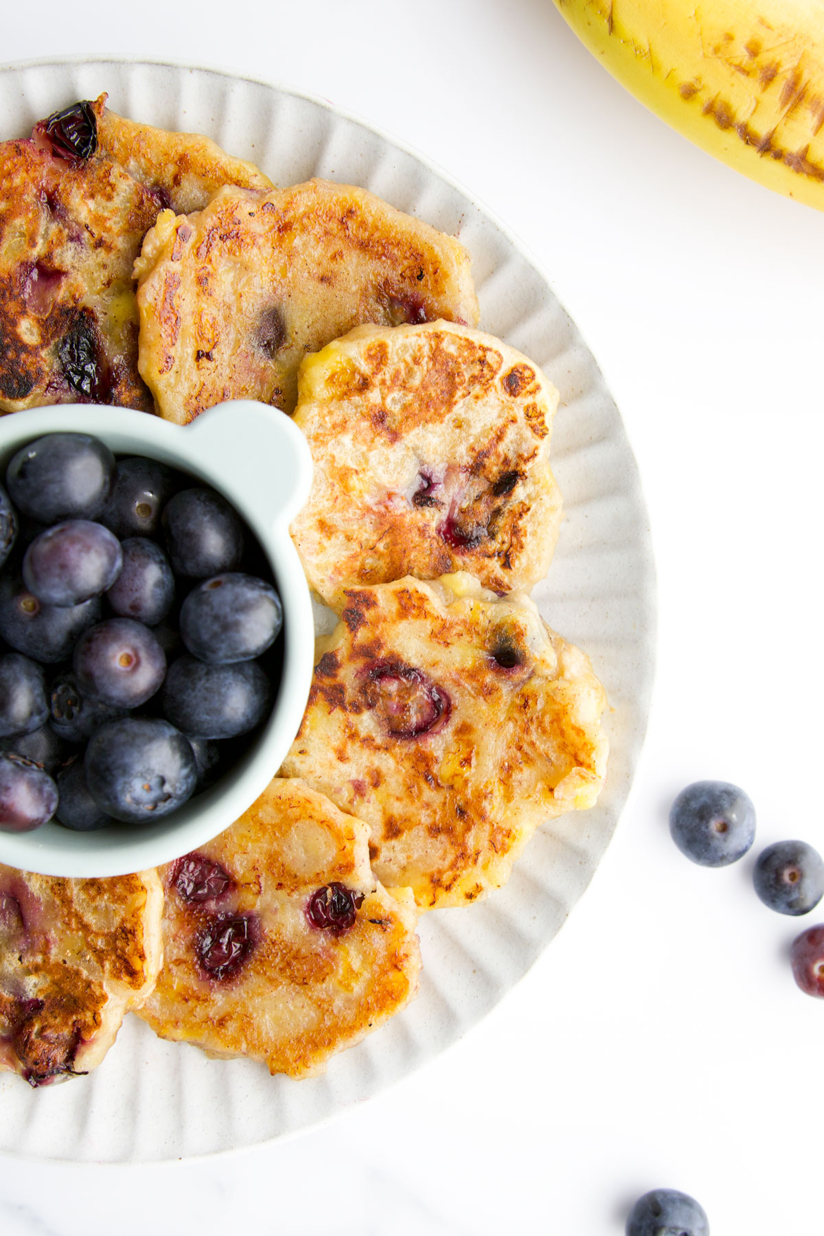 Banana Blueberry Fritters on Plate with Small Dish of Blueberries. 