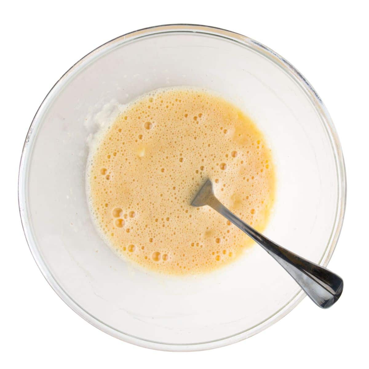 Mashed Banana and Egg Mixed Together in Glass Bowl. 