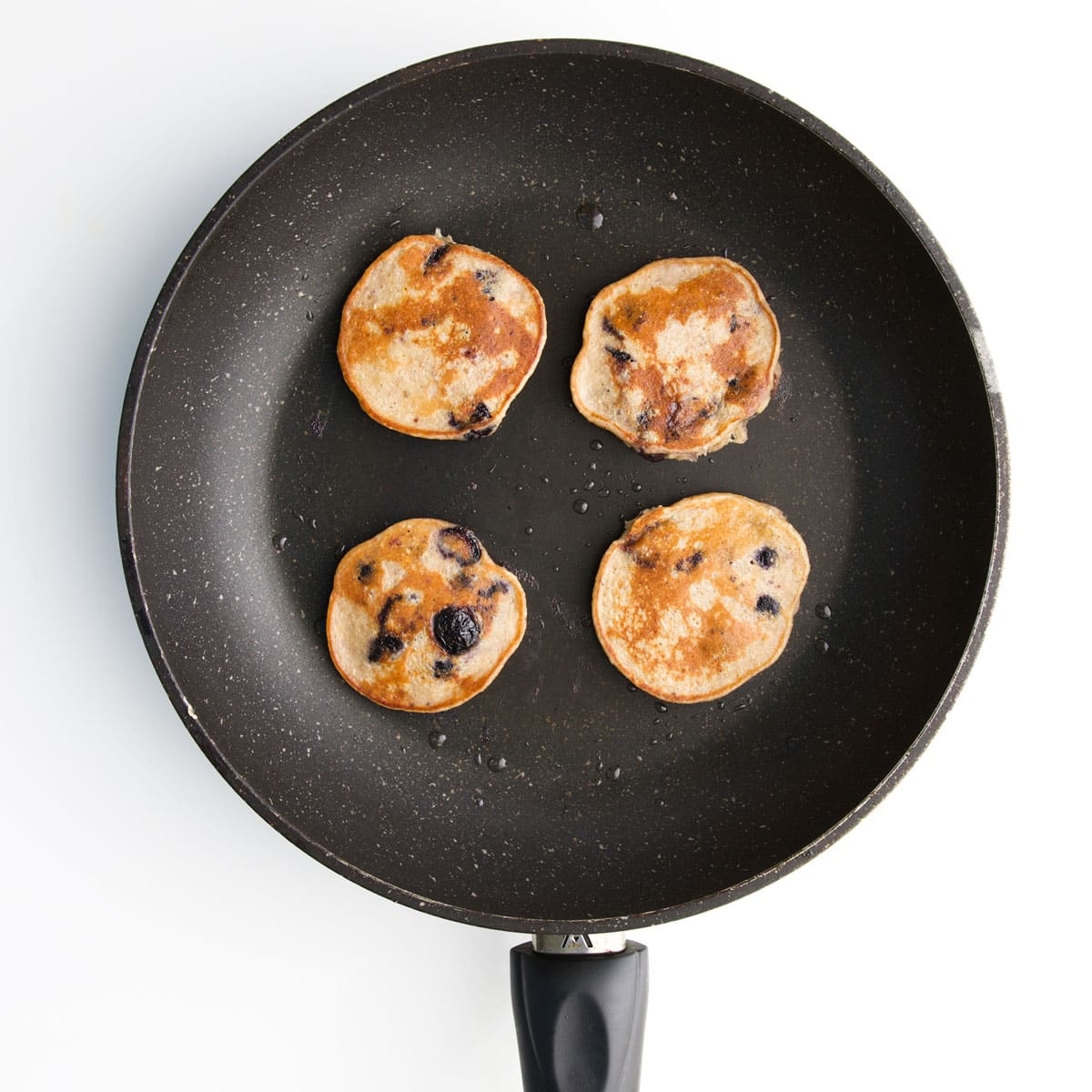 Cooked Blueberry Baby Pancakes in Pan. 