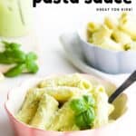 Pinterest Pin Showing Image of Bowl of Cooked Pasta Covered in a Creamy Basil Pesto Sauce and Garnished With Fresh Basil and Parmesan Cheese.