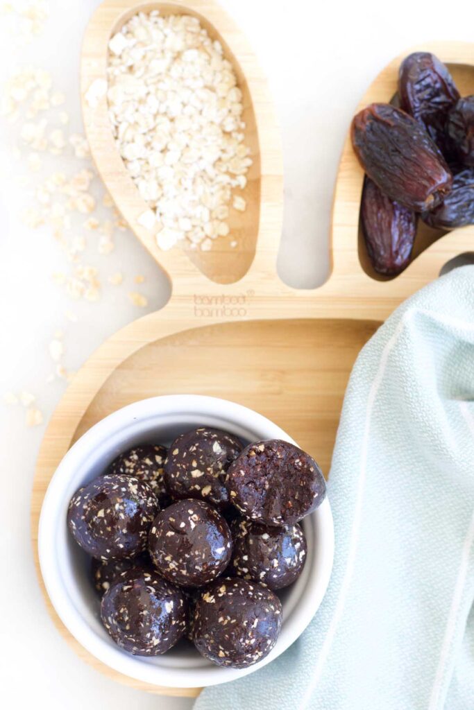 Top Down Shot Of Cocoa Energy Balls in Bowl Sitting on Wooden Bunny Shaped Plate