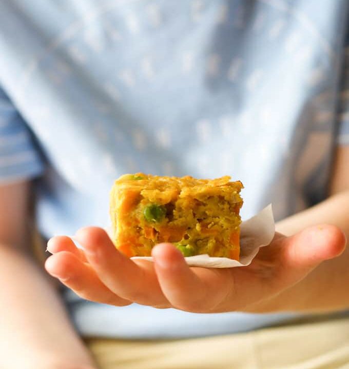 Child holding a slice of lentil bake