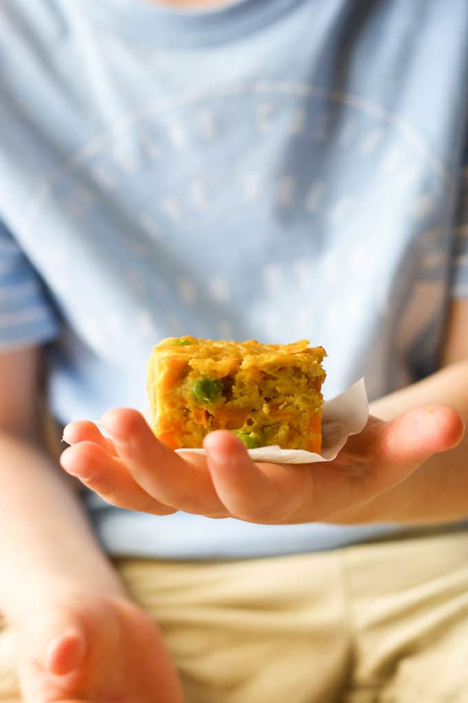 Child holding a slice of lentil bake