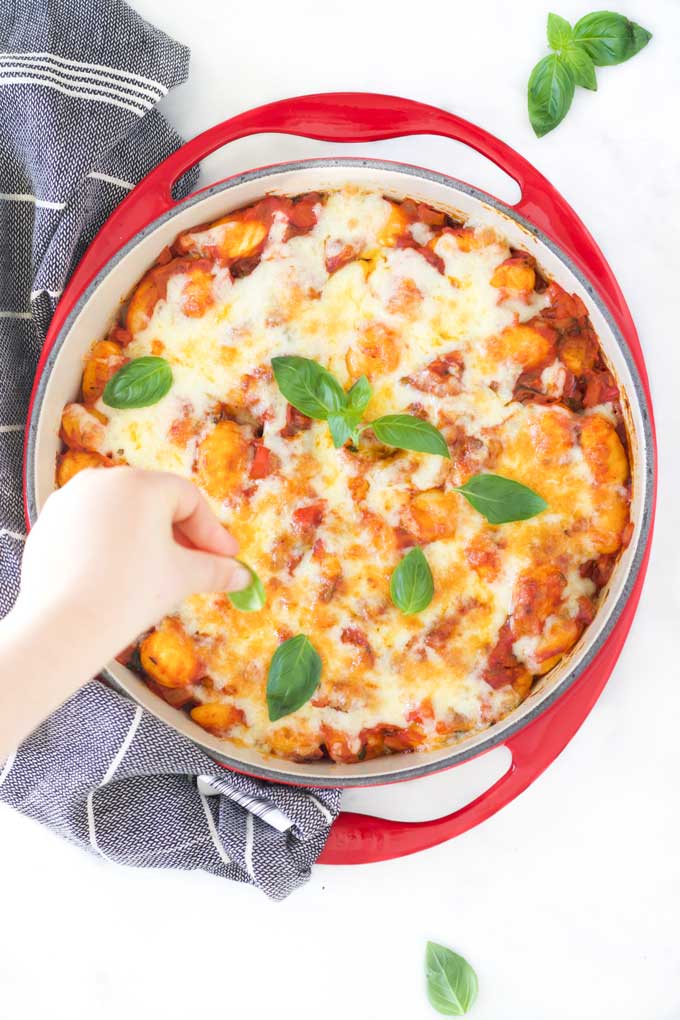 Child Placing Basil Onto a Gnocchi Bake