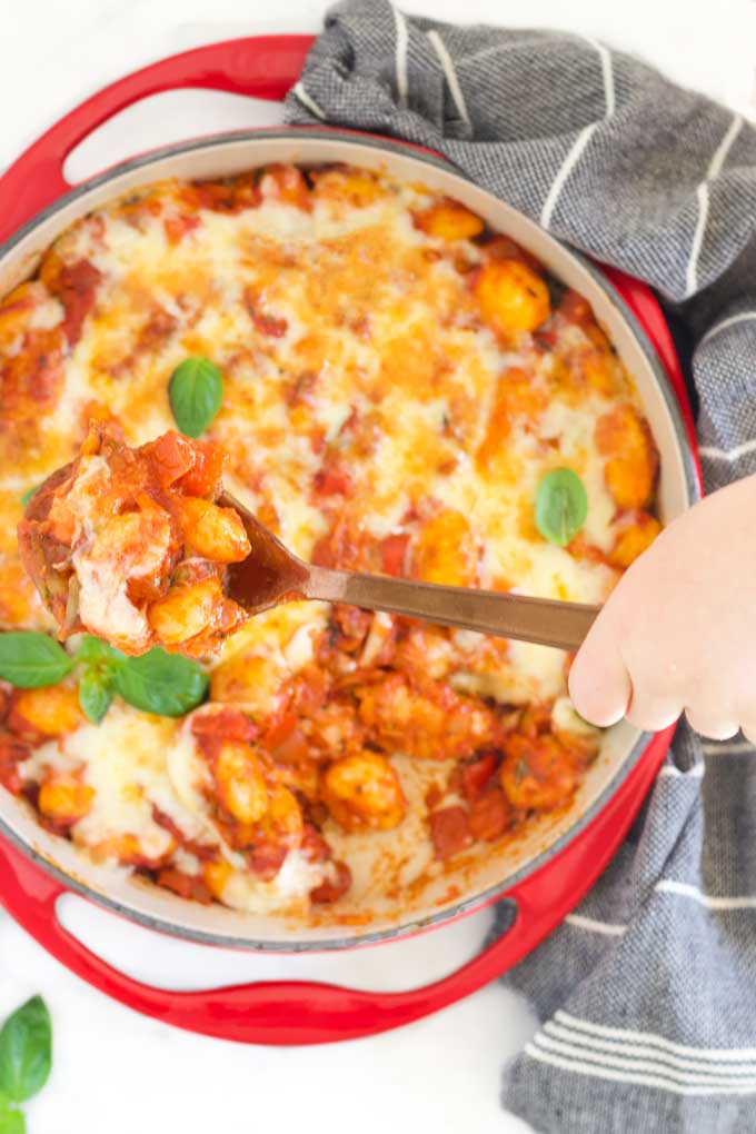 Child Removing Spoon of Gnocchi Bake from Dish