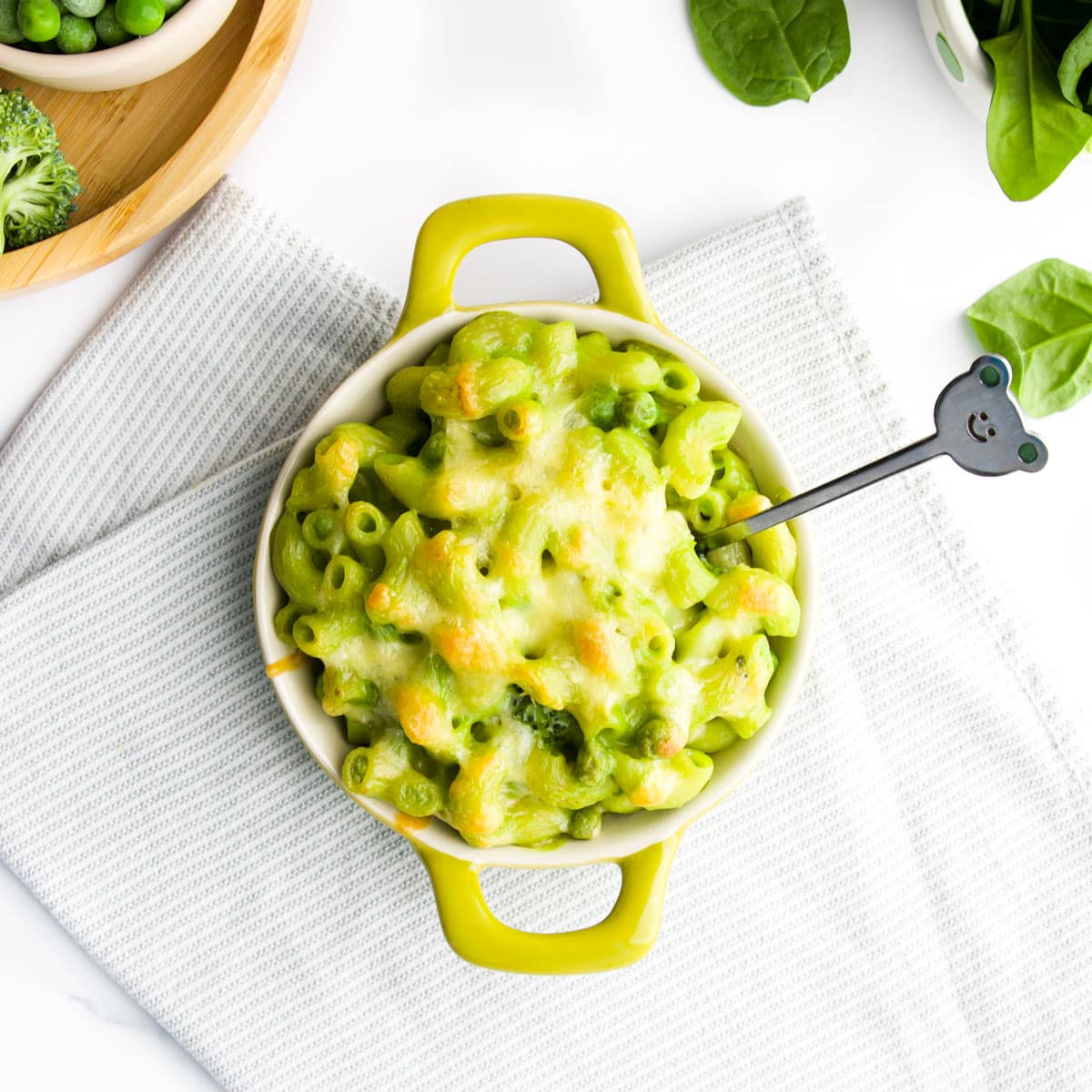 Green Mac and Cheese in Small Dish Topped with Cheese.