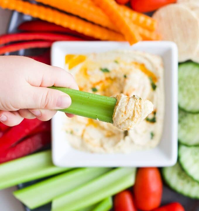 Kid Dipping Celery into Hummus