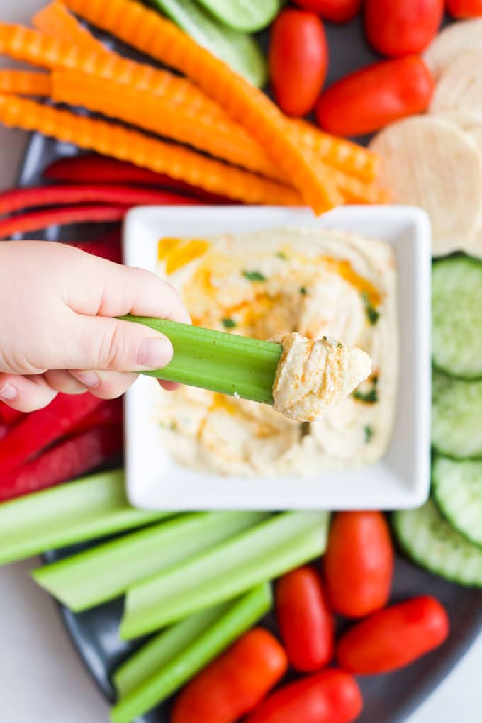 Kid Dipping Celery into Hummus