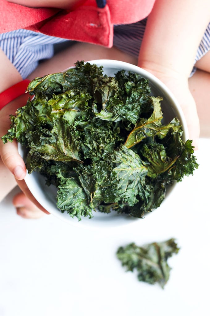 Child Holding a Bowl of Baked Kale Chips