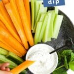 Child Dipping Carrot in Mint Yogurt Dip with Text Overlay "Mint Yogurt Dip"