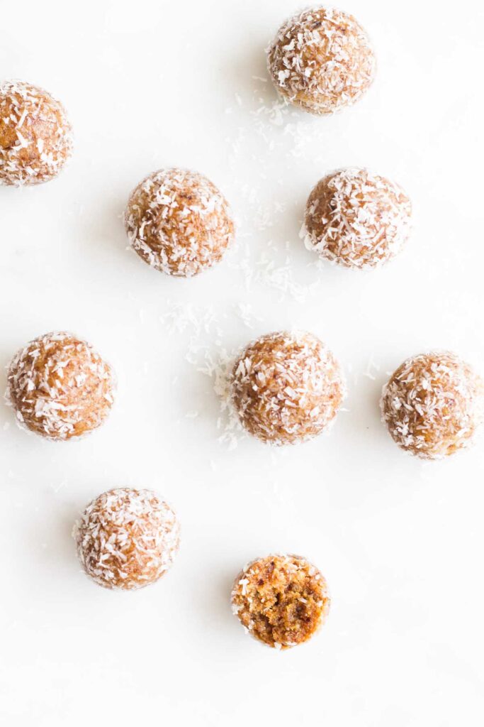 Top Down Shot of Nut Balls On Marble Surface. One With Bite Out of It