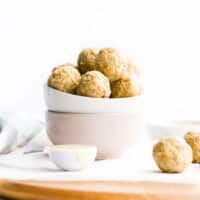 Nut Free Bliss Balls in Stacked Bowls with Balls in Foreground.