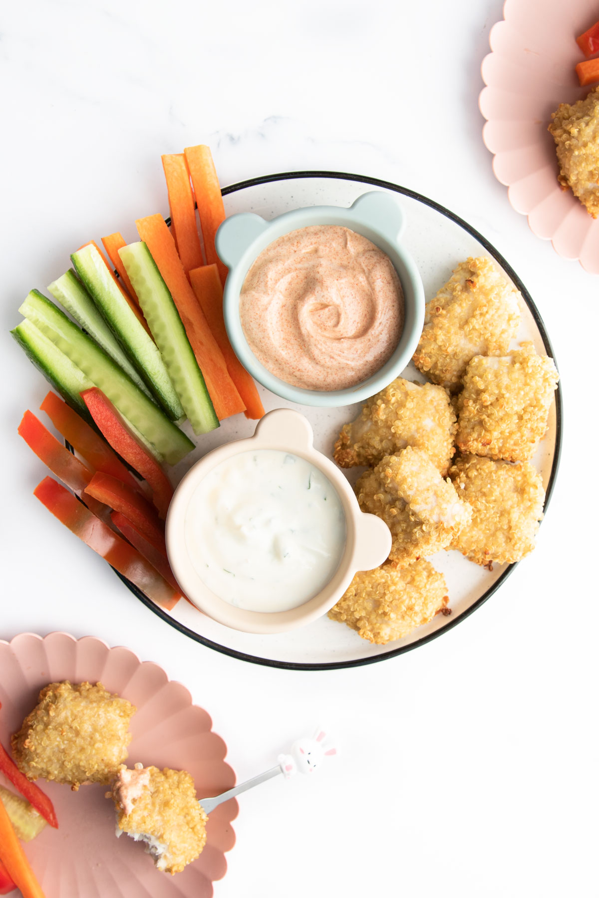 Plate of Quinoa Chicken Nuggets, Chopped Veggies and Dips. Two Plates off to the Side with Served Portions.