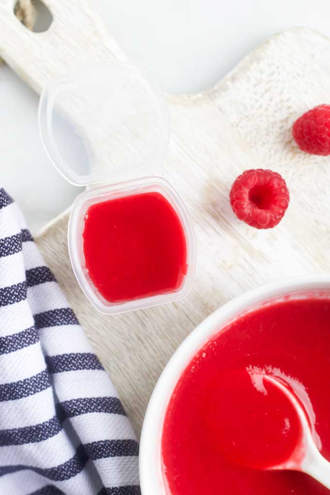 Raspberry Puree Added to Freezable Containers for Freezing.