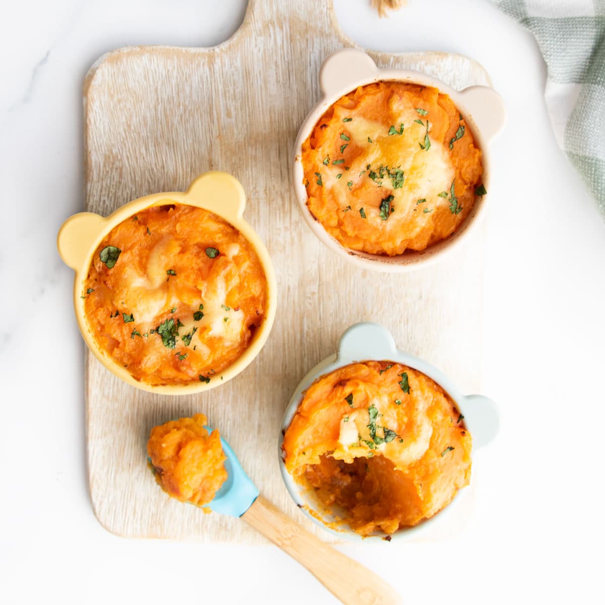 Red Lentil Pie in 3 Baby Dishes with a Spoonful. removed from one. 