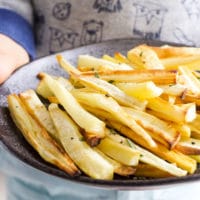 Child Holding a Plate of Roasted Parsnips