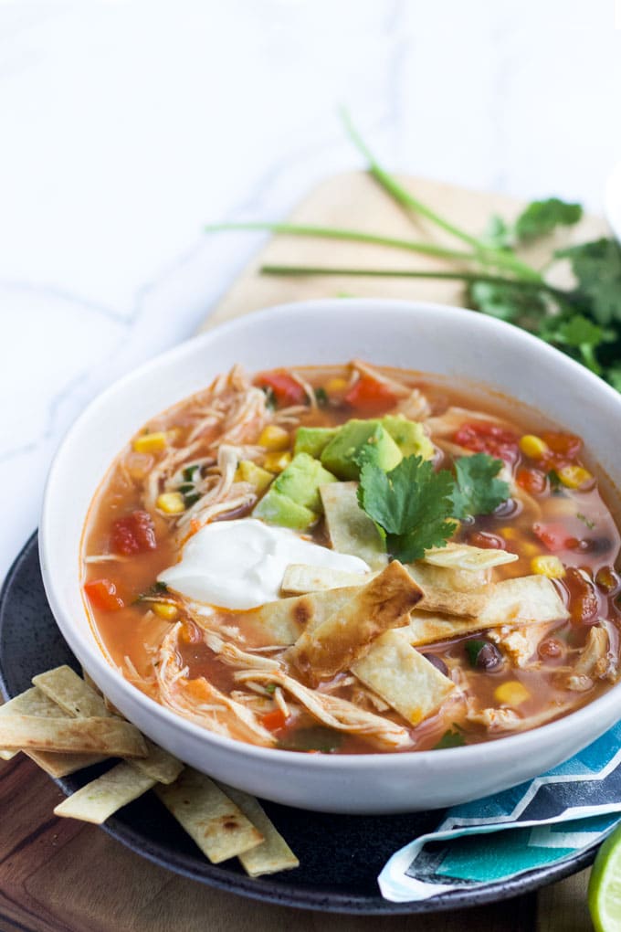 Bowl of Slow Cooker Chicken Tortilla Soup Topped with Avocado and Yoghurt