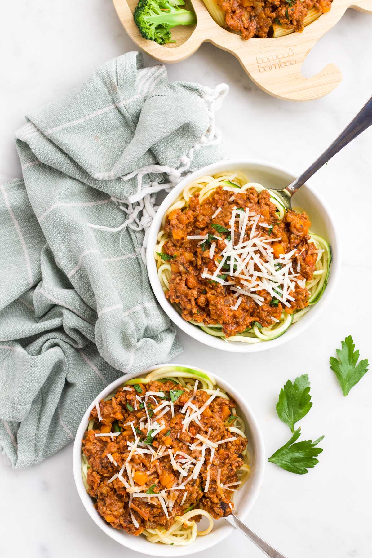 Top Down View of Two Bowls of Spaghetti Bolognese with Baby Plate in Background