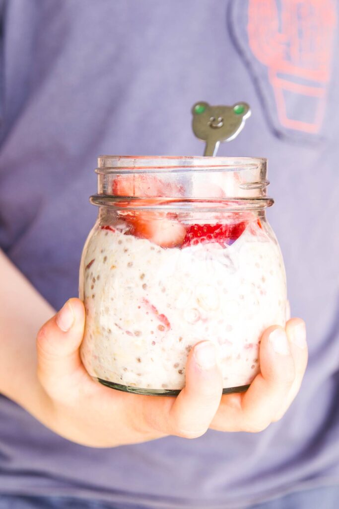 Child Holding Jar of Strawberry Overnight Oats