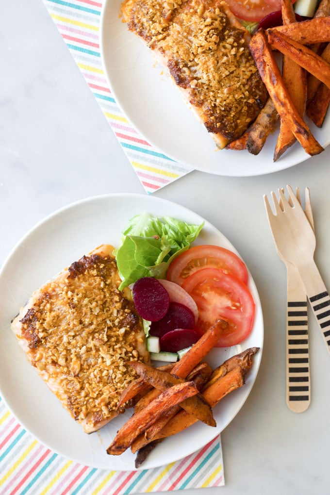 Top Down View of Plated Sun-dried Tomato Baked Slalom, Sweet Potato Fries and a Salad