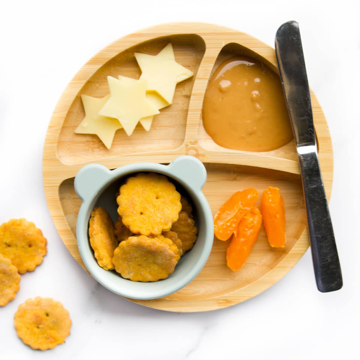 Sweet Potato Crackers on Toddler Plate With Cheese Stars, Satsuma and Peanut Butter. 