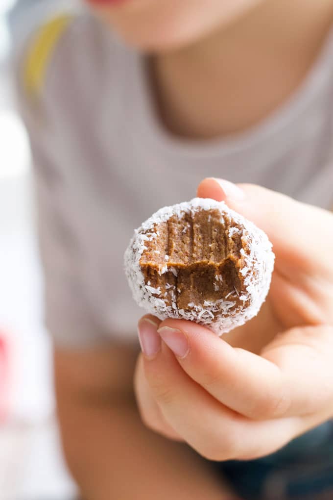 Child Holding Sweet Potato Truffle with Bite Out of It