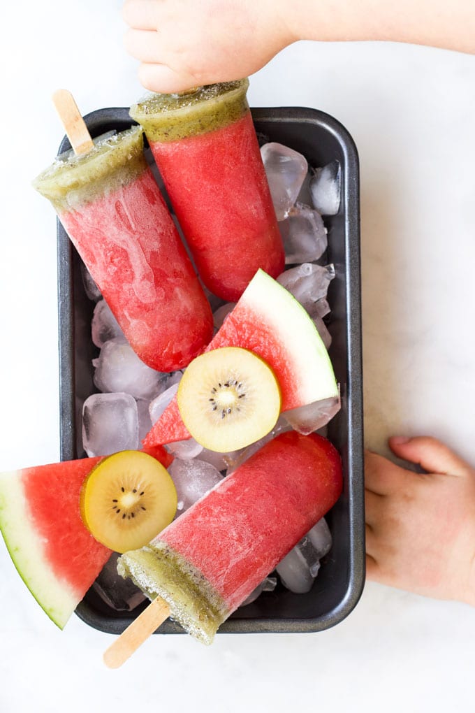 Child Grabbing Watermelon Popsicle from Tray