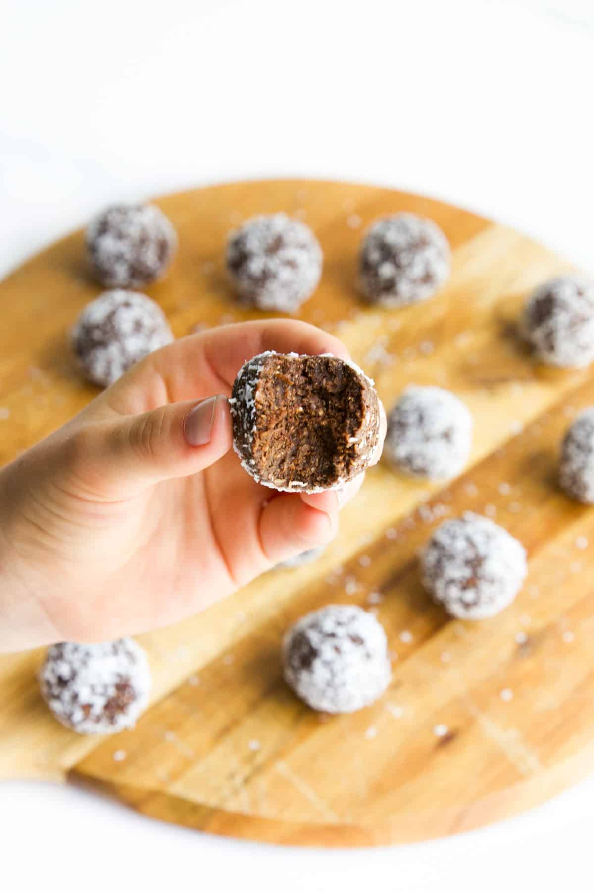 Close Up Shot of Hand Holding Weetbix Ball With Bite Removed.